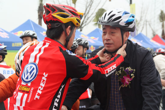 专业车手为即将出发的成都市体育局局长覃文林戴头盔