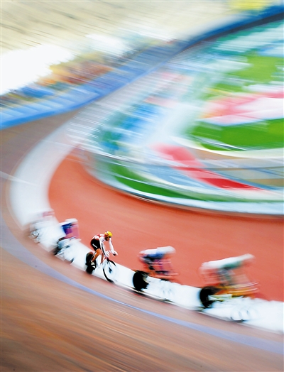 一个橘红色的身影掠过弧形的赛道，速度之快让人们几乎无法看清此人的面容。只见这个身影像一团疾驰的火焰，燃烧起整个自行车馆内所有观众的热情。在一片惊叹与欢呼声中，这团火焰已冲至终点。